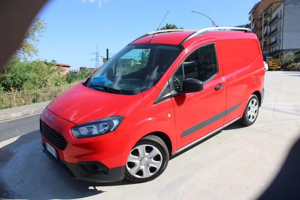 Ford furgonato rosso con barre sul tetto nel piazzale di Autocento